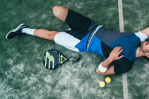 tennis-player-laying-on-on-ground-after-round